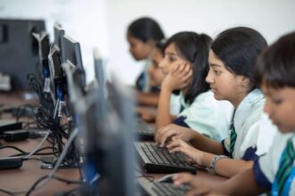 Surveillant en collège discutant avec des élèves dans une cour de récréation