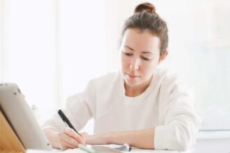 Étudiant stressé examinant ses résultats universitaires dans une bibliothèque
