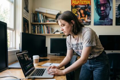 Jeune femme en classe éditant une vidéo sur son ordinateur